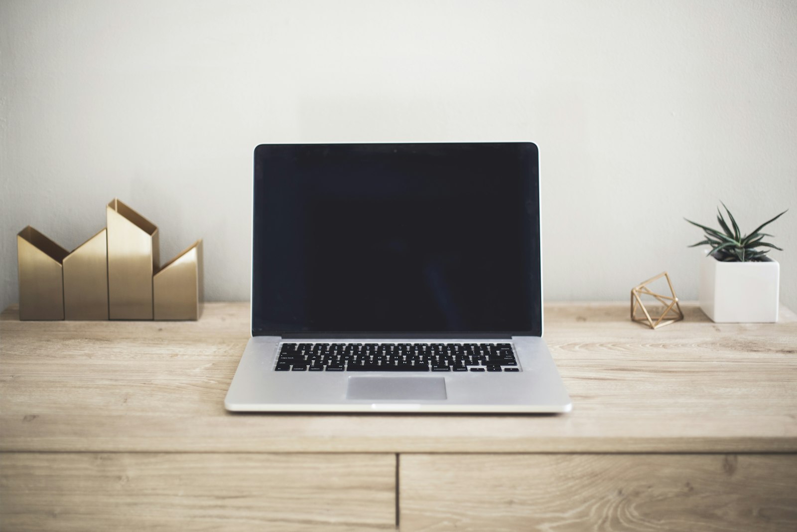 A laptop open on a wooden desk, ready for a day of calls